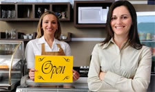 Small business owner with open for business sign